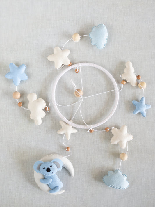 Flat lay of the Sleep Tight handcrafted baby cot mobile featuring a sleeping koala, crescent moon, soft clouds, stars, and wooden bead accents for nursery decoration.