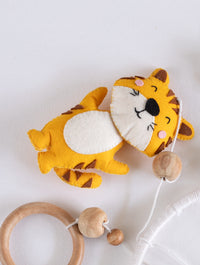 Soft handcrafted felt tiger ornament from the Baby Being crib mobile with natural wooden beads, designed for cheerful jungle-themed baby room décor.