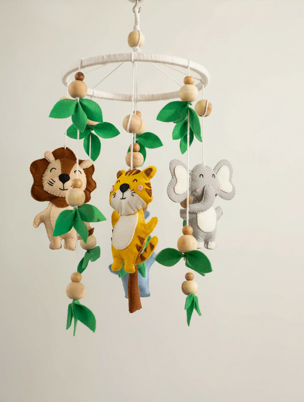 Baby Being premium handcrafted felt baby cot mobile with safari animals, wooden beads, and leafy accents, designed to create a soothing jungle-themed nursery.