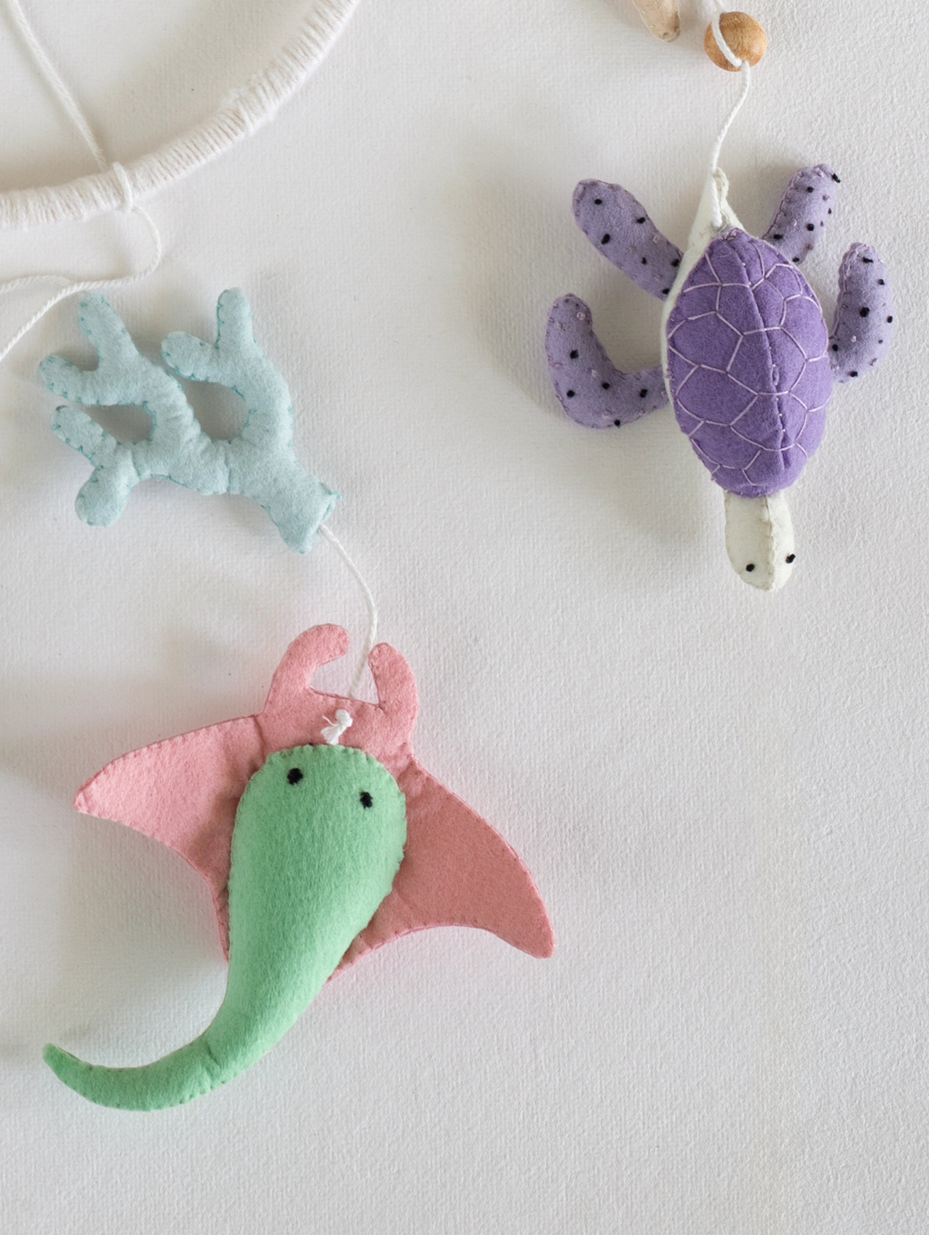 Handcrafted felt turtle and manta ray ornaments from the Deep in the Ocean baby mobile, designed to create a whimsical underwater nursery atmosphere.