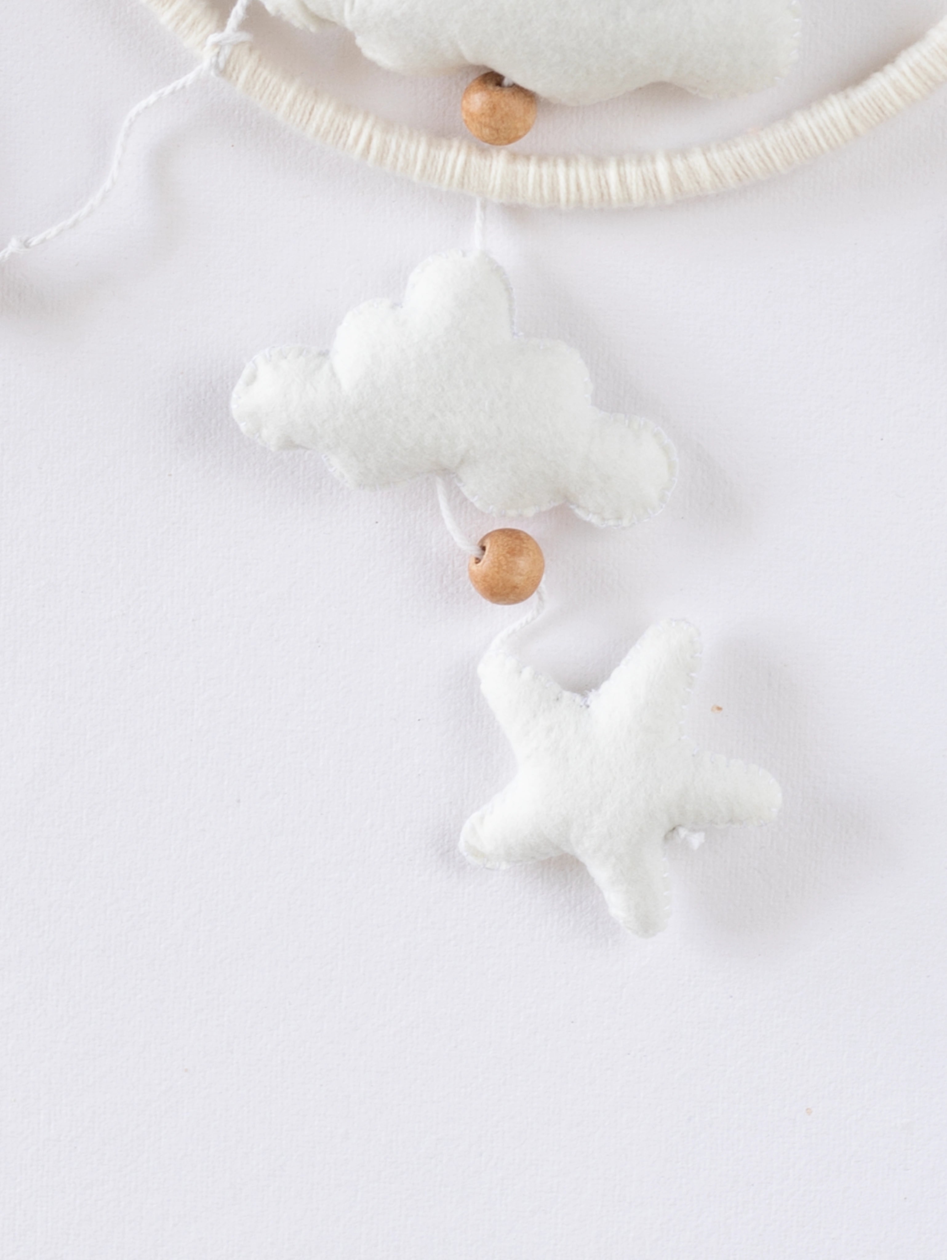 Plush felt cloud and star hanging ornaments from the Fly High crib mobile, adding a soft celestial touch to baby nursery interiors.