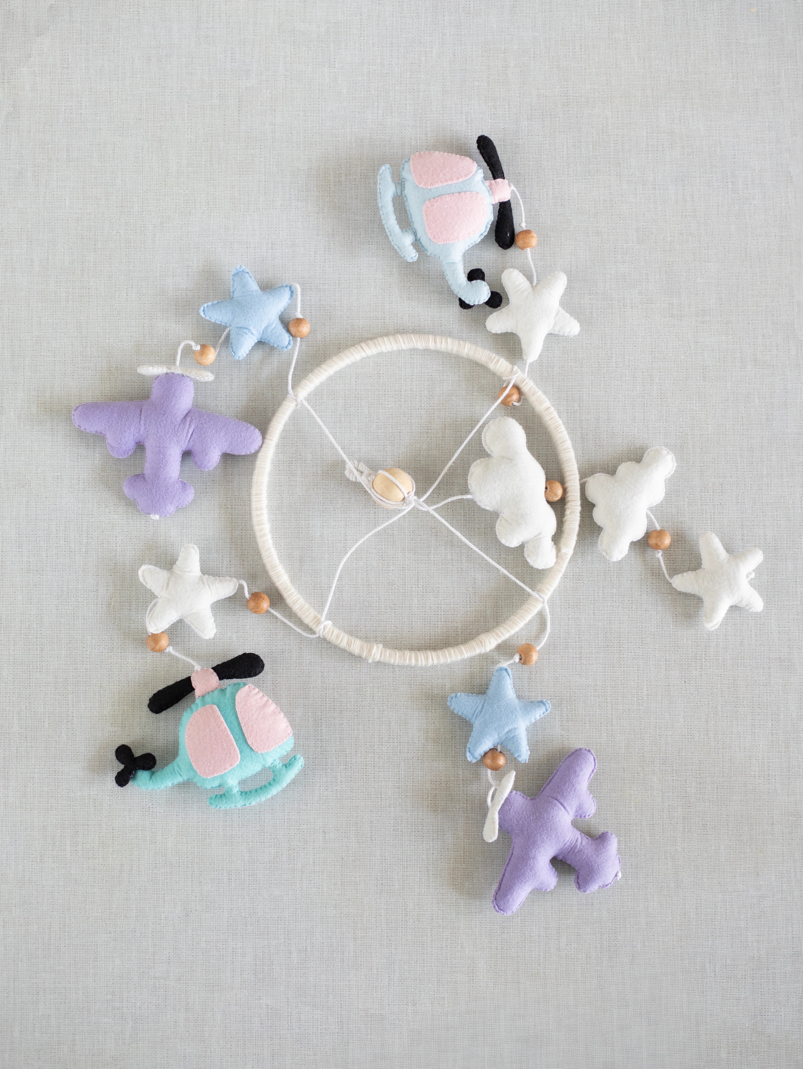 Complete Fly High felt crib mobile laid flat, showcasing handcrafted helicopters, airplanes, clouds, stars, moon, and premium nursery décor details.