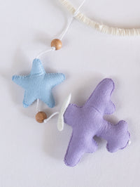 Lavender felt airplane paired with a pastel blue star from the Fly High baby mobile, handcrafted to create a calming sky-inspired nursery.