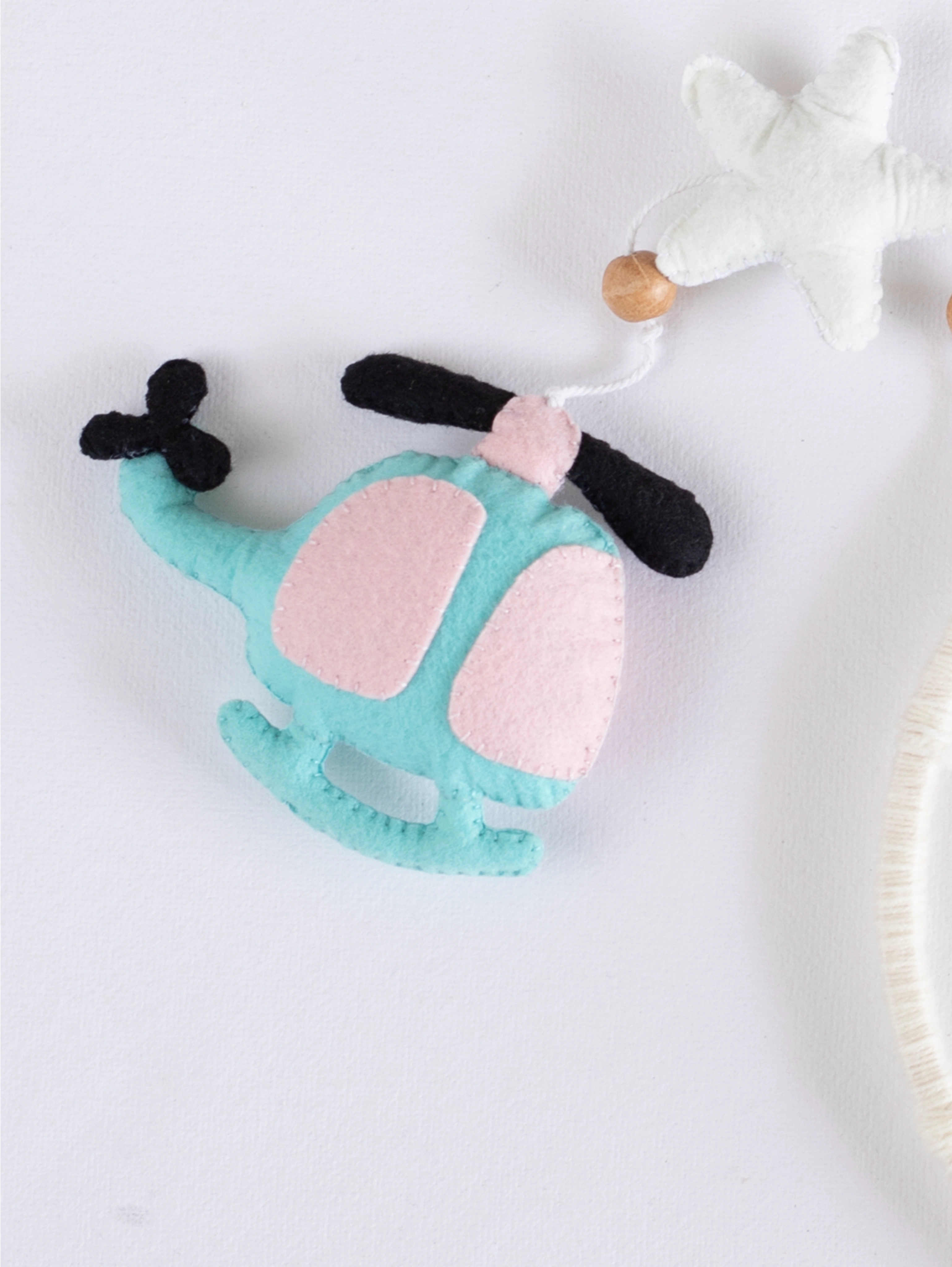 Soft handcrafted felt helicopter ornament from the Fly High nursery mobile, created for modern baby rooms with aviation-inspired décor.
