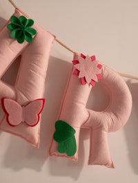 Close-up of the handcrafted felt letter R from the Garvita personalized nursery banner with floral and leaf embellishments.