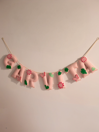 Garvita personalized blush pink felt name banner with handcrafted floral, butterfly and leaf accents for elegant baby nursery wall decor.
