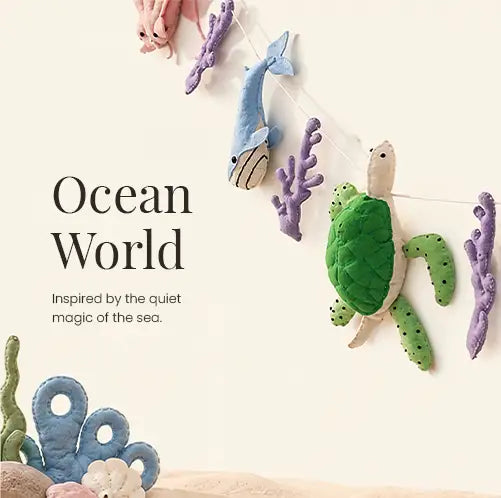 Handmade felt ocean animal garland featuring a green sea turtle, blue whale, purple coral and seahorse — soft plush nursery wall decor inspired by the sea, ideal as a newborn baby gift