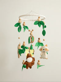 Into the Wild premium handcrafted felt baby cot mobile featuring woodland animals, natural wooden elements, and forest leaves for elegant nursery décor.