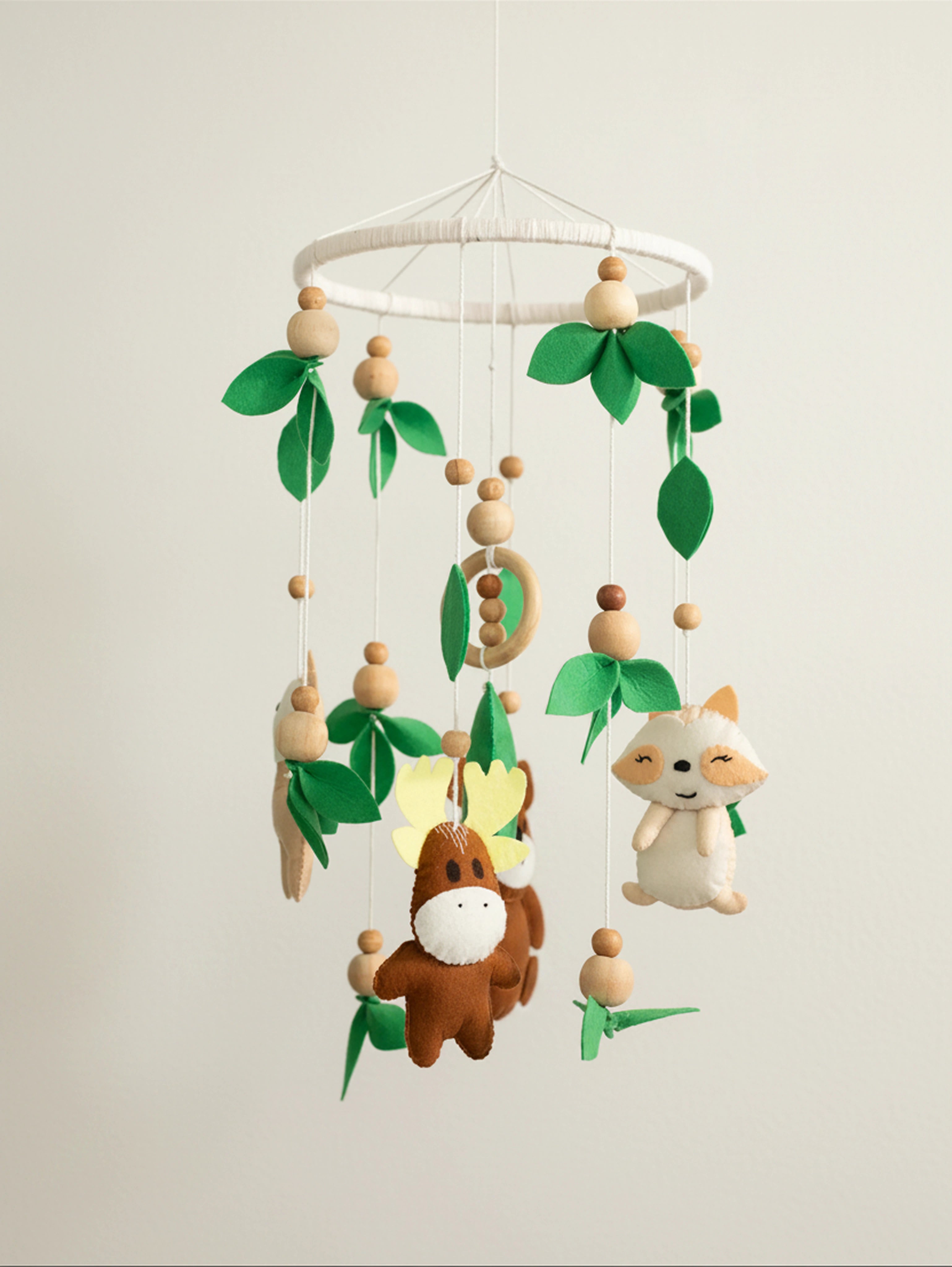 Into the Wild premium handcrafted felt baby cot mobile featuring woodland animals, natural wooden elements, and forest leaves for elegant nursery décor.