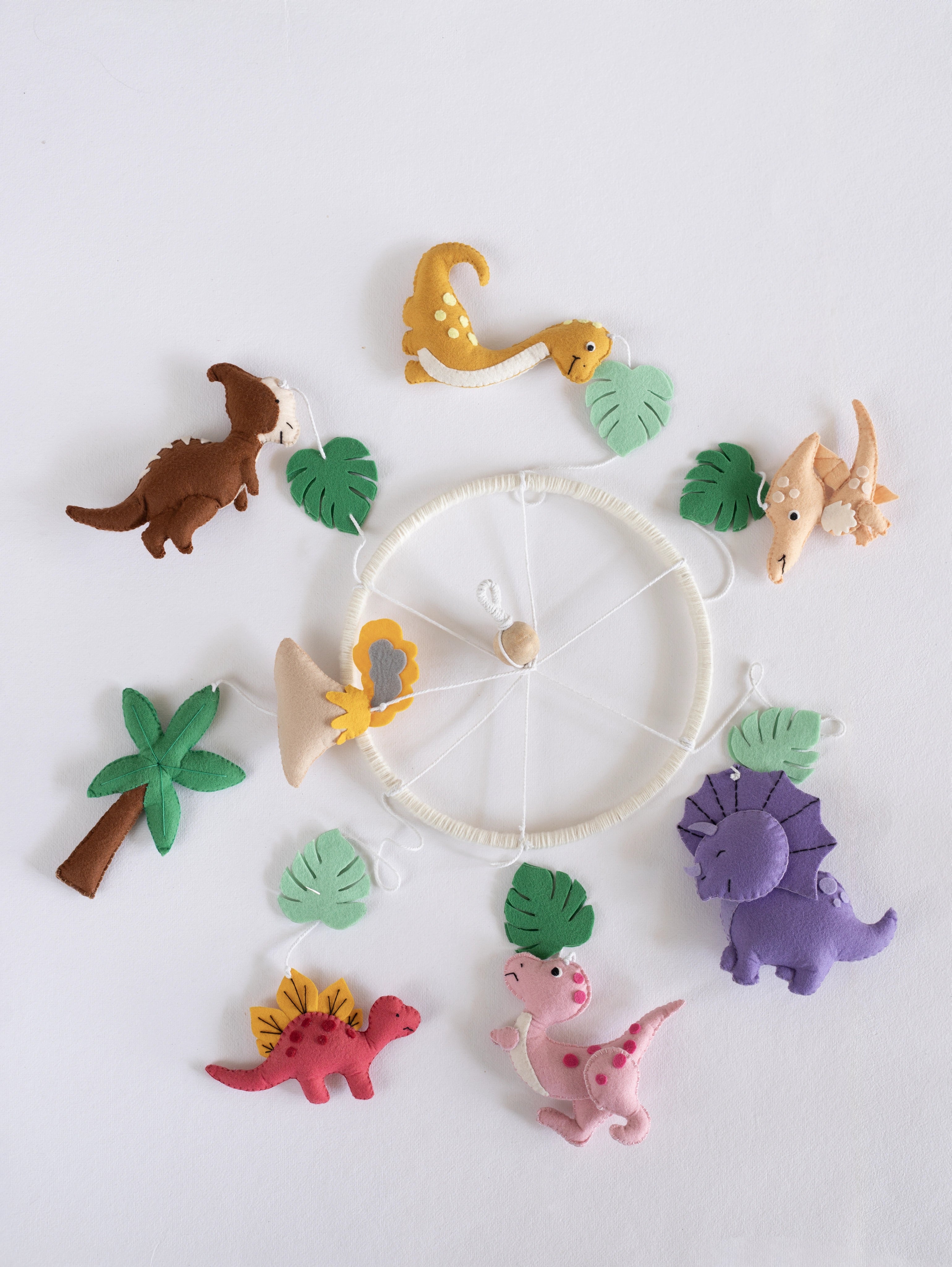 Complete Roar Away handcrafted felt dinosaur cot mobile showcasing colorful dinosaurs, tropical leaves, volcano, palm tree, and jungle-inspired nursery décor.