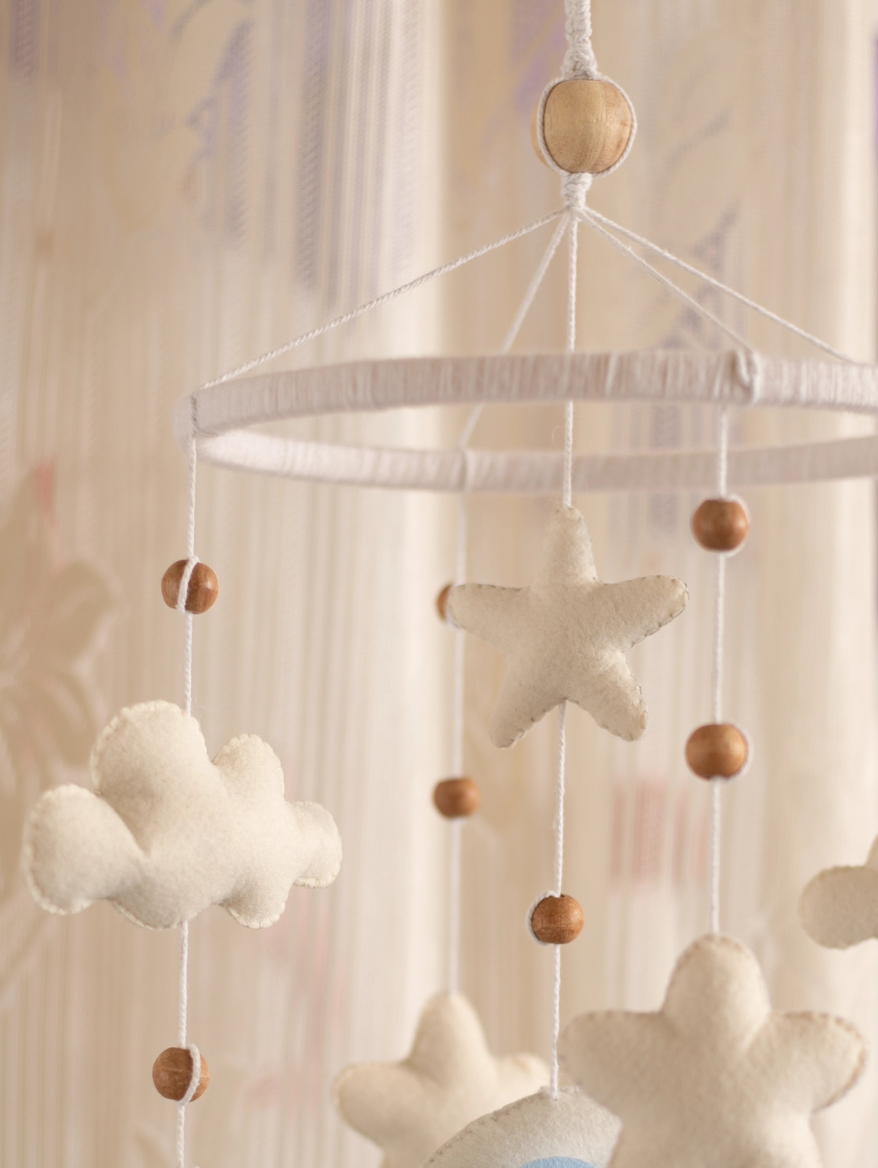 Close-up of the Sleep Tight nursery cot mobile with plush clouds, felt stars, natural wooden beads, and handcrafted hanging details for a dreamy baby room.