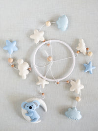 Flat lay of the Sleep Tight handcrafted baby cot mobile featuring a sleeping koala, crescent moon, soft clouds, stars, and wooden bead accents for nursery decoration.