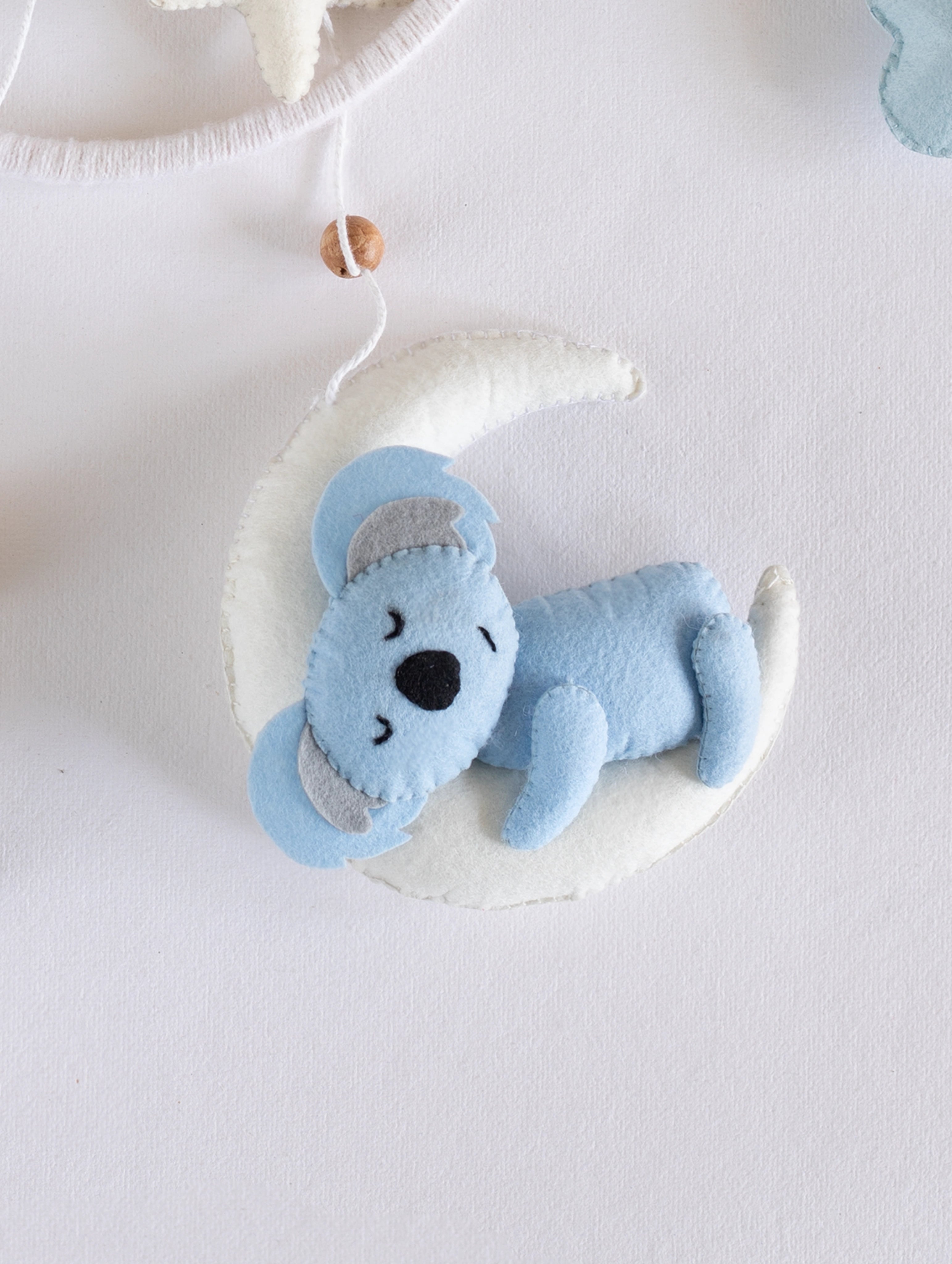 Adorable handcrafted sleeping koala on a crescent moon from the Sleep Tight baby mobile, designed to create a calm and comforting nursery atmosphere.