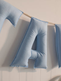 Close-up of the blue felt letter ‘A’ on the personalized Taksh nursery name banner with handcrafted stitching details