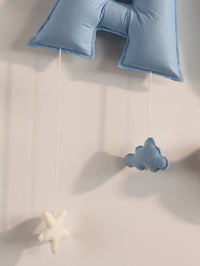 Detailed view of the lower blue felt letter with a handcrafted cloud ornament on the personalized Taksh baby name banner.