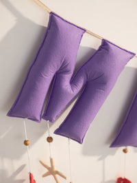 Detailed close-up of the ‘M’ letters on the personalized Miraya felt name banner, handcrafted in purple felt for an ocean-themed nursery