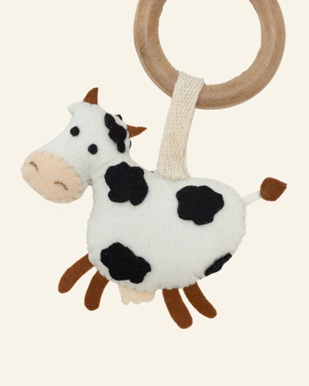 Close-up of Moo handmade cow baby hanging toy showcasing premium felt craftsmanship, embroidered facial details, soft textures, and a playful nursery accessory for babies and toddlers.