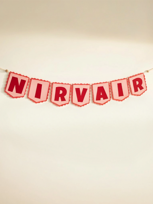 Full view of the personalized Nirvair felt name banner featuring handcrafted red and white letters for nursery wall décor.