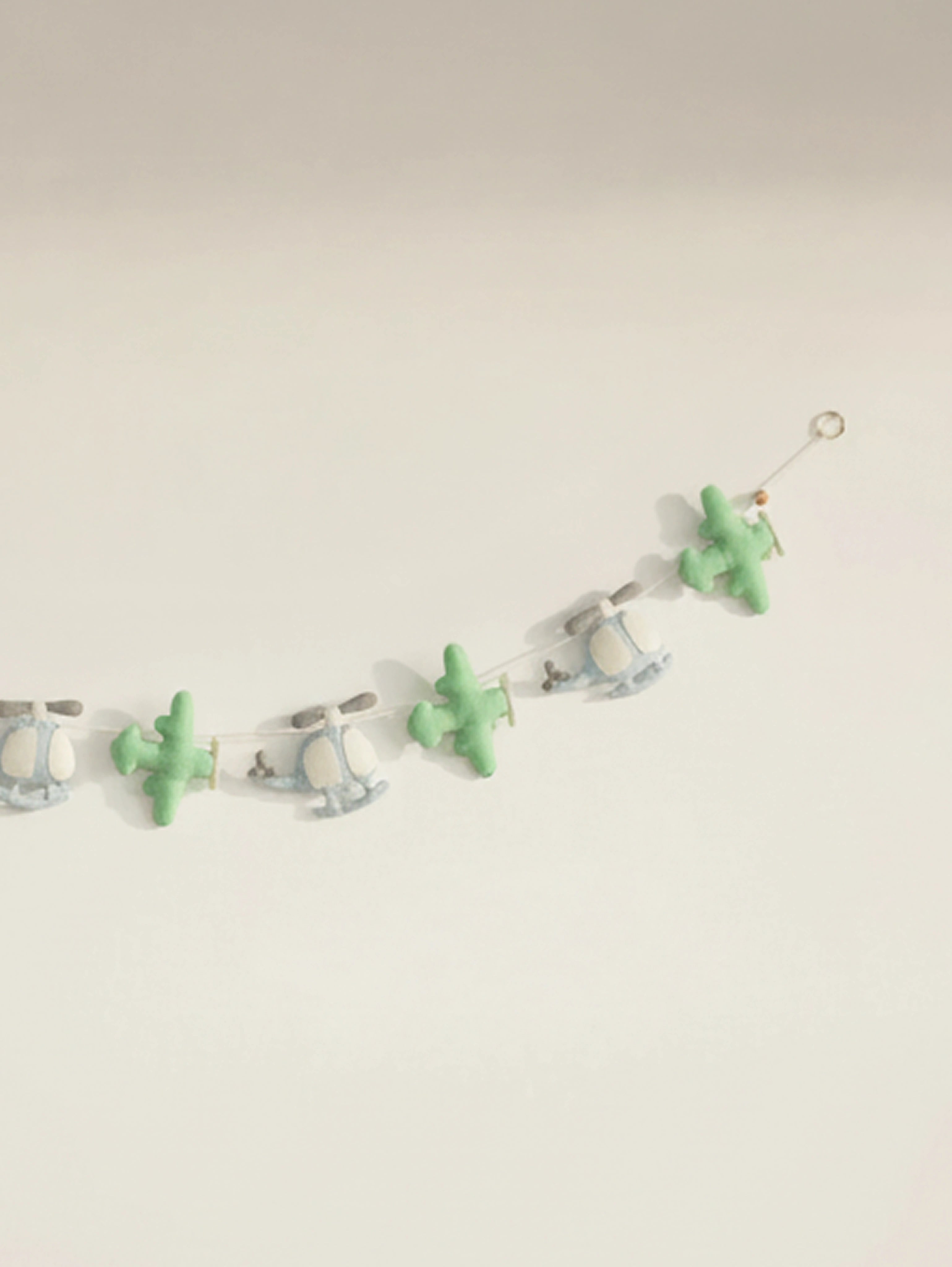 Detailed right-side view of the To The Moon nursery garland with stitched felt helicopters and airplanes for aviation-themed baby decor.
