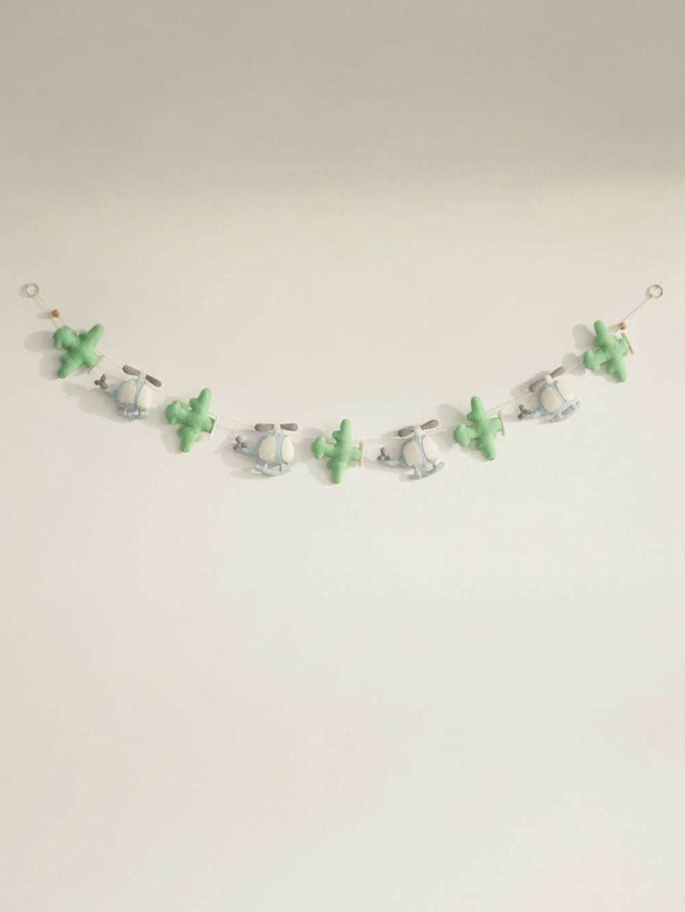 Handcrafted To The Moon felt nursery banner featuring pastel green airplanes and blue helicopters for baby room wall decoration.