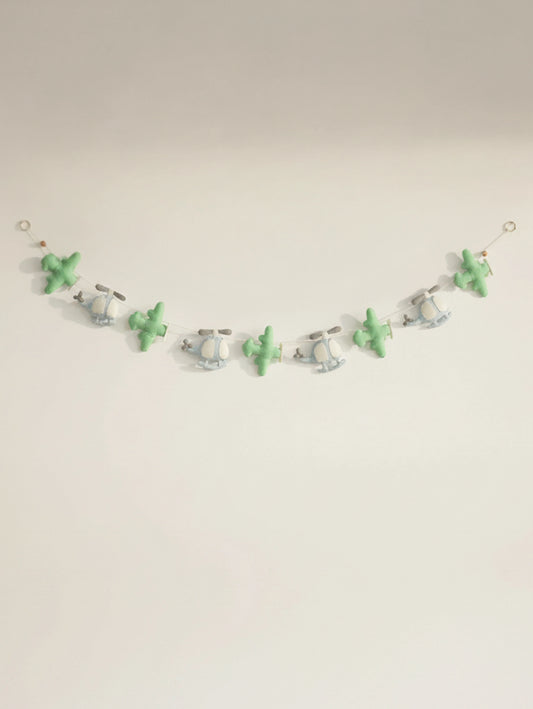 Handcrafted To The Moon felt nursery banner featuring pastel green airplanes and blue helicopters for baby room wall decoration.