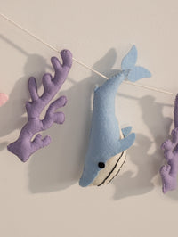 Handcrafted blue felt whale paired with purple coral accents on the Under the Sea nursery banner for playful ocean-inspired wall decor.