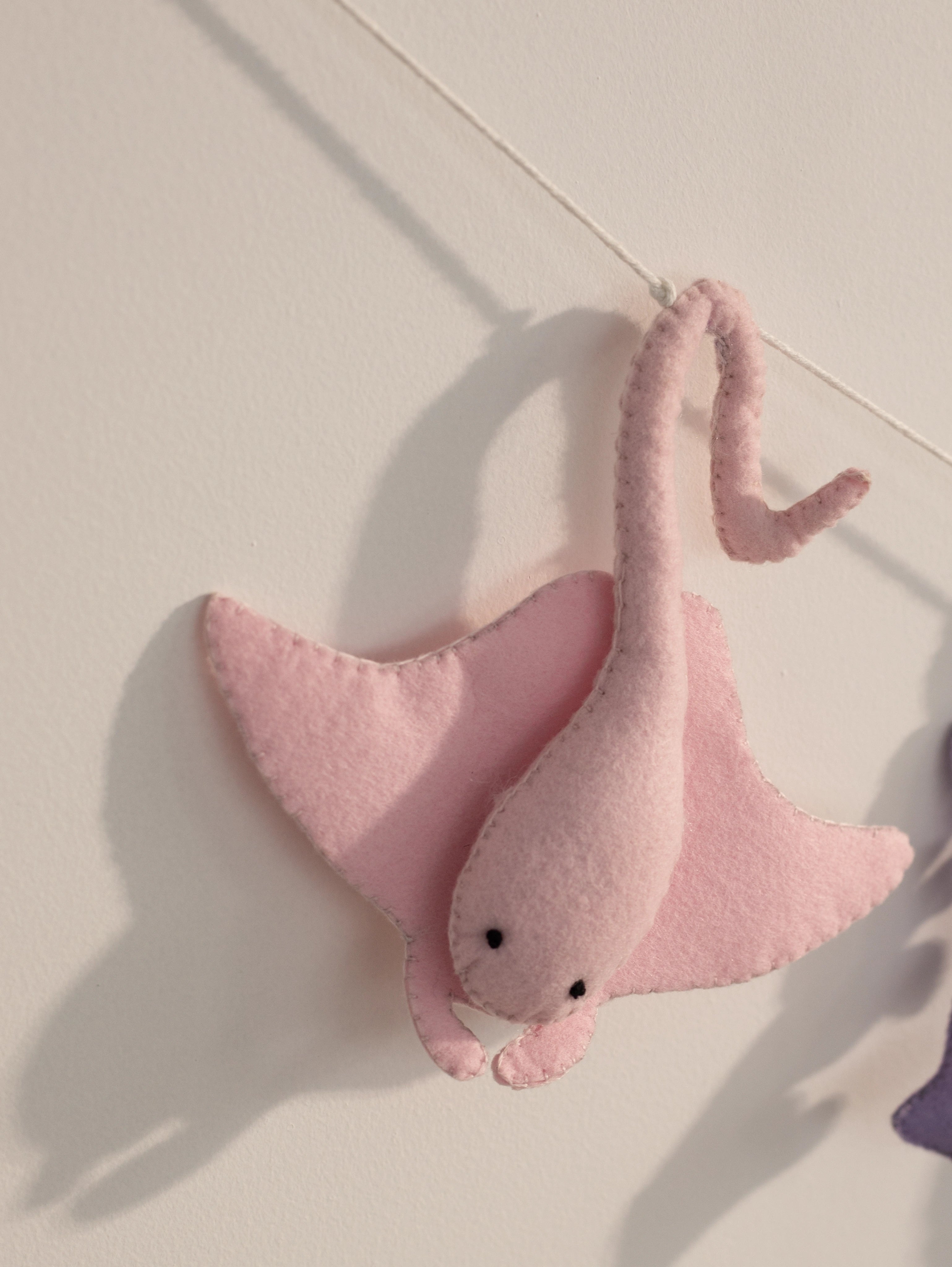 Close-up of a handcrafted pink felt stingray from the Under the Sea nursery banner with soft stitched details for ocean-themed baby room decor.