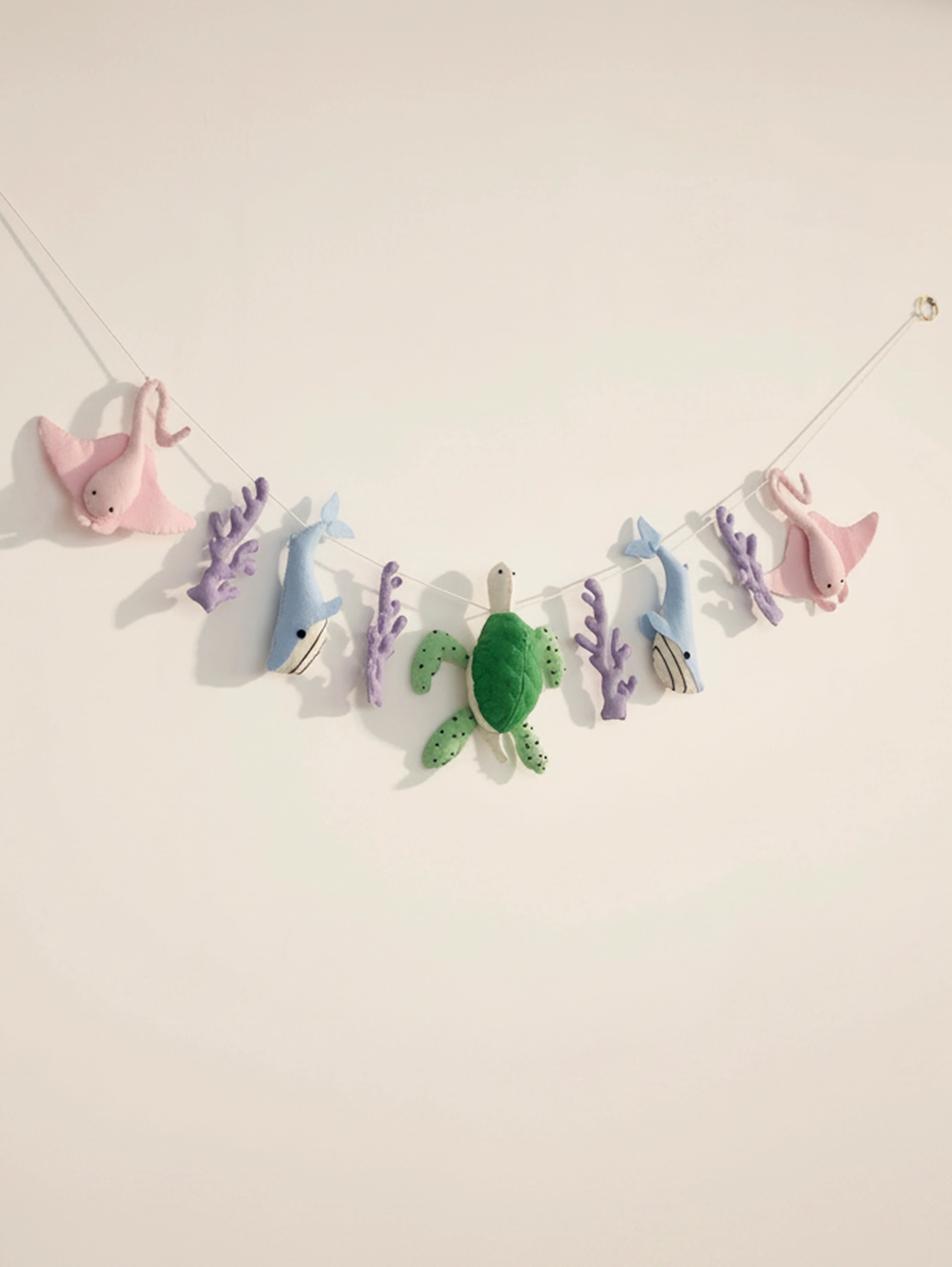 Full view of the Under the Sea handcrafted felt nursery banner featuring stingrays, whales, sea turtles and coral for ocean-themed baby room decor.