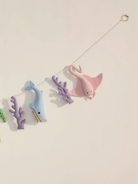 Right-side close-up of the Under the Sea felt wall banner highlighting a pink stingray, whale and coral decorations for a modern nursery.